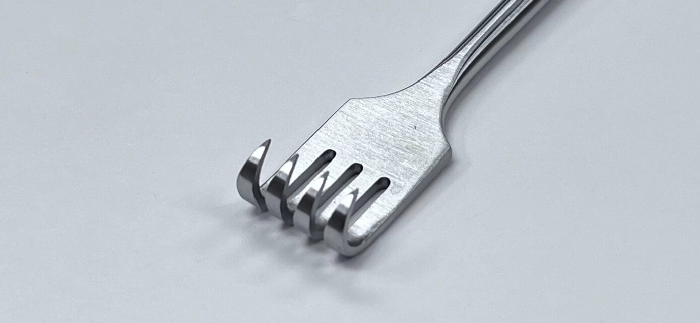 A Murphy retractor on a white surface.