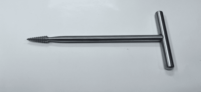 An image of a T handle cork screw on a white surface.