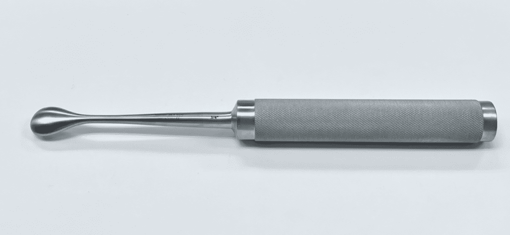 A COBB SPINAL ELEVATOR with a handle on a white surface.