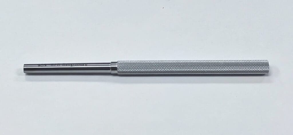 A BONE TAMP with a metal handle on a white surface.