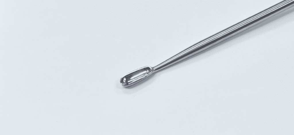 A LARGE BONE CURETTE on a white surface.