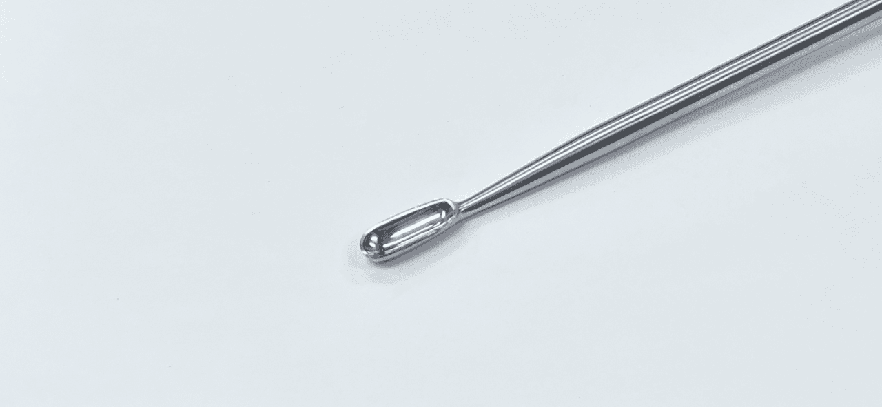 A LARGE BONE CURETTE on a white surface.