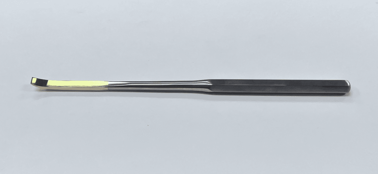 A black and yellow CEMENT REMOVER CHISEL on a white surface.