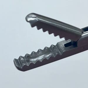 A close up of a CEMENT RONGEUR with teeth on it.