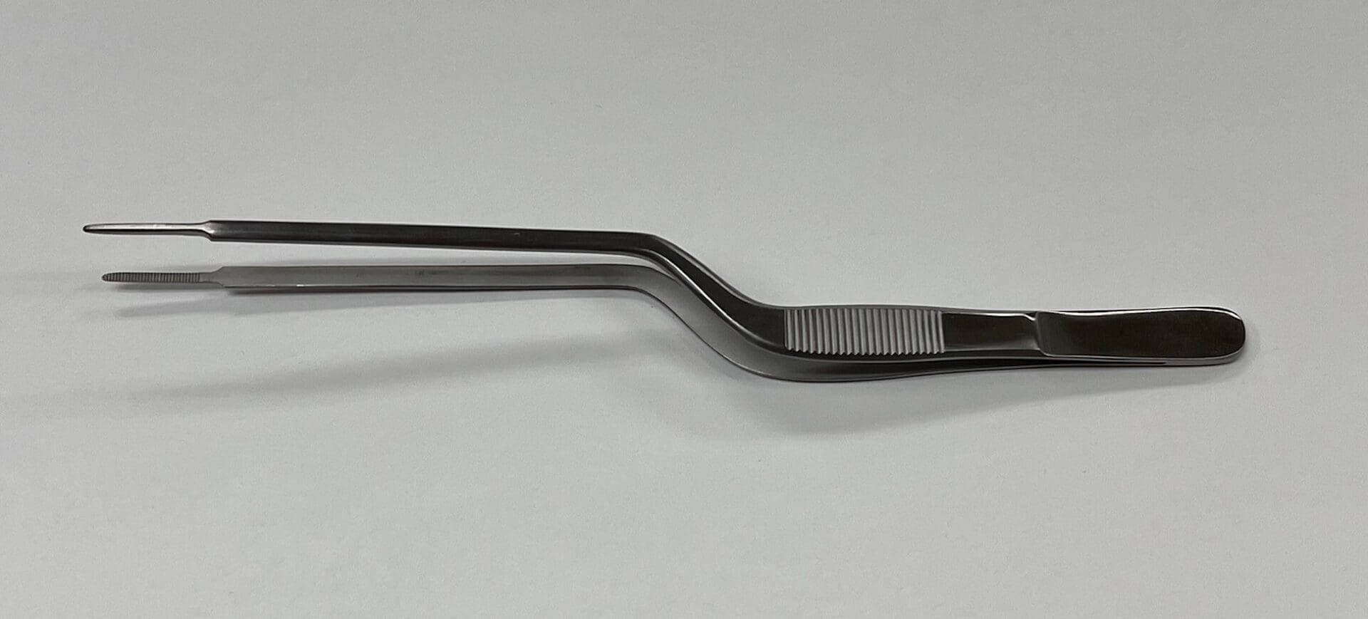 A pair of GERALD DRESSING FORCEP, BAYONET dressing forceps on a white surface.
