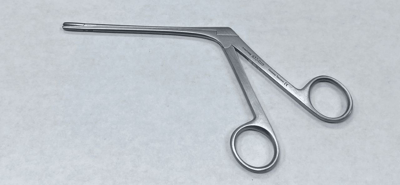 A pair of Takahashi forceps on a white surface.