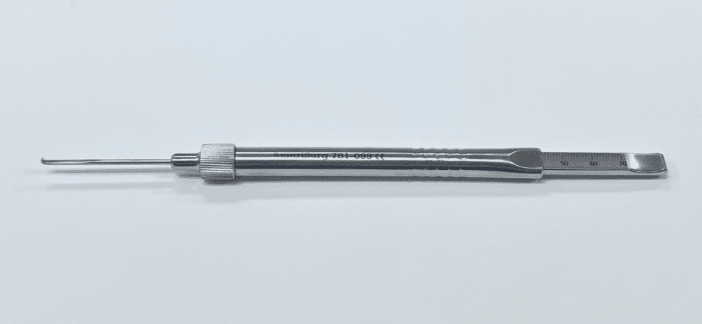 A large screw depth gauge with a metal handle on a white surface.