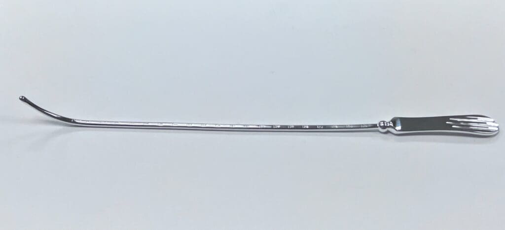 A SIMS UTERINE SOUND with a handle on a white surface.
