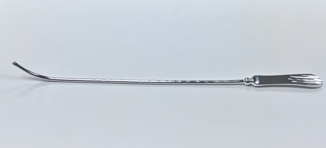 A SIMS UTERINE SOUND with a handle on a white surface.