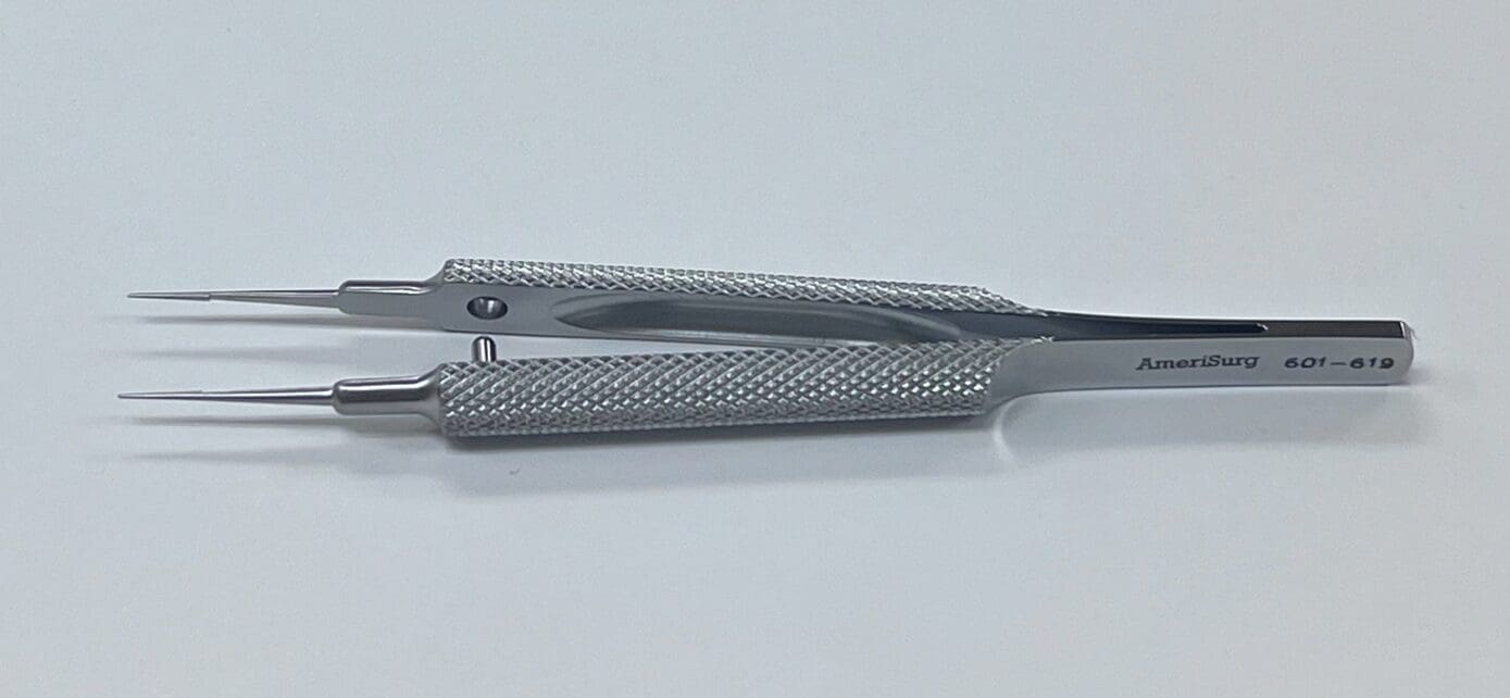 A pair of TENNANT TYING FORCEP on a white surface.