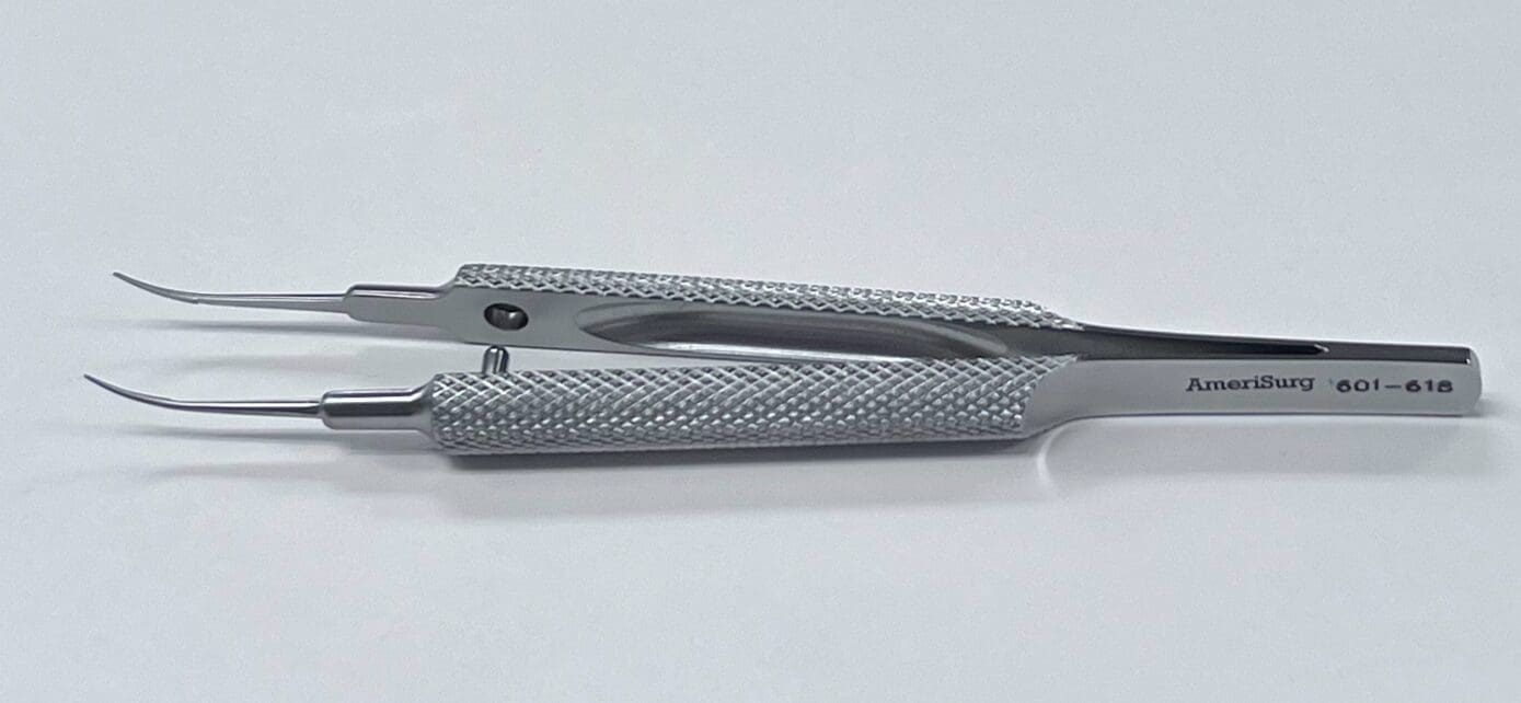 A pair of TENNANT TYING FORCEP tweezers on a white surface.