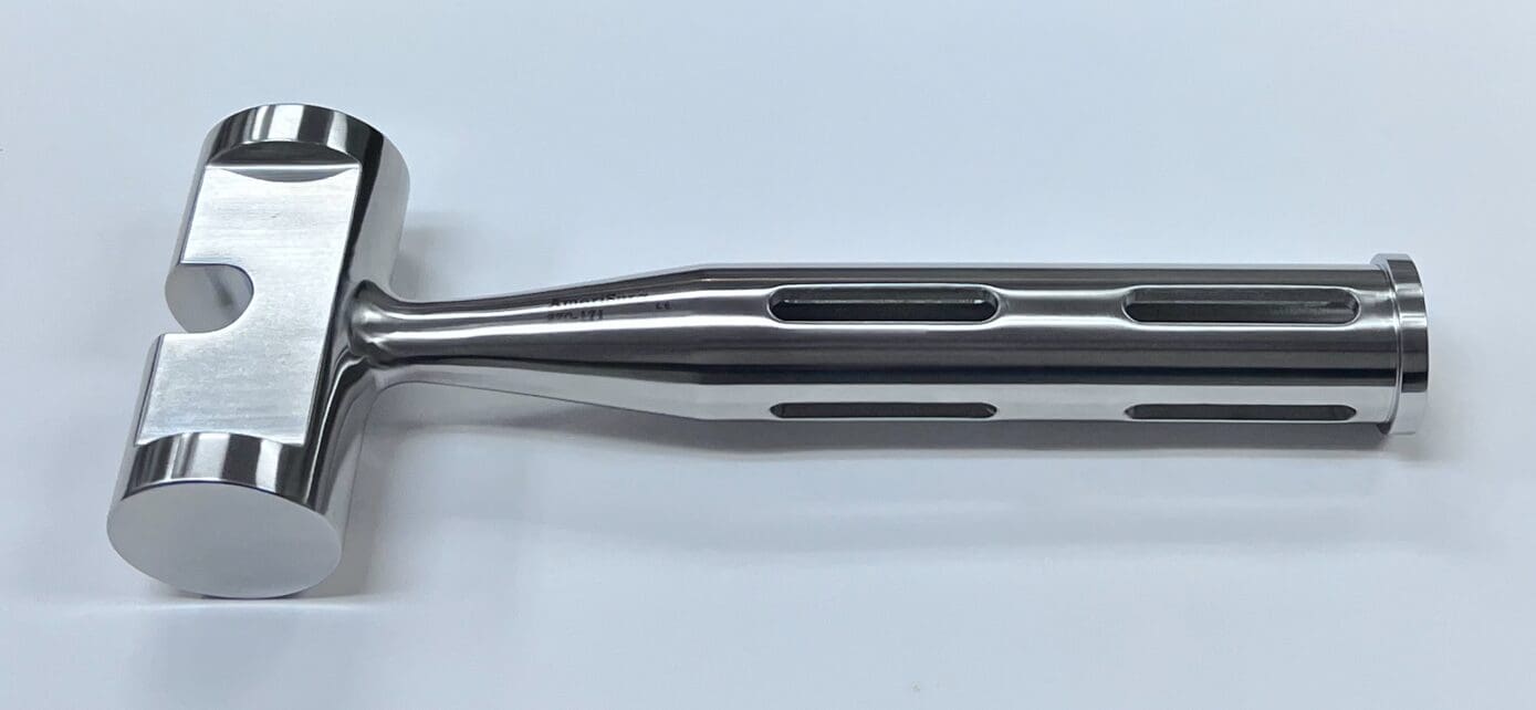 A slotted mallet on a white surface.